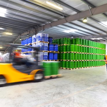 group of workers in the logistics industry work in a warehouse with chemicals - lifting truck